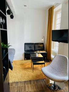 a living room with a black couch and a table at Forenom Serviced Apartments Göteborg Geijersgatan in Gothenburg