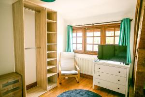 um quarto com uma televisão numa cómoda e uma janela em Chambres d Hôte Bords de Seine Vernon-Giverny em Vernon