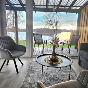 een woonkamer met een tafel en stoelen en een groot raam bij Volunge house in Doškonys