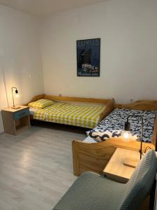 two beds in a room with a table and a chair at Nona - 200m from the beach in Jadranovo