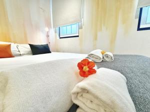 - une chambre avec un lit, des serviettes et une fleur rouge dans l'établissement Curious Crow Studio 1 by Homeful Homes, à Lisbonne