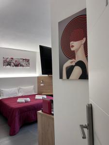 una habitación con una cama y una foto de una mujer en Longevity Hotel, en Tortolì