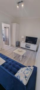 a living room with a blue couch and a table at 2 x Bedroom Deluxe Hampton Apartment in Shoal Bay
