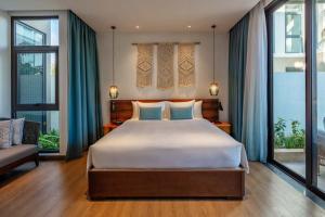 a bedroom with a large bed with blue pillows at New World Phu Quoc Resort in Phú Quốc