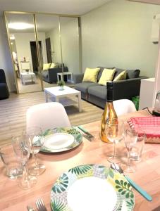 a dining table with a bottle of wine and glasses at Studio soleil plage in Deauville