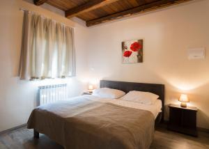 a bedroom with a bed with two lamps and a window at Guest House Valentincic in Nova Gorica