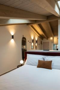 una camera da letto con un grande letto con lenzuola bianche di Palais Bernadette a Parma