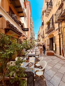 a row of tables and chairs on a street at Monteleone rooms in Palermo