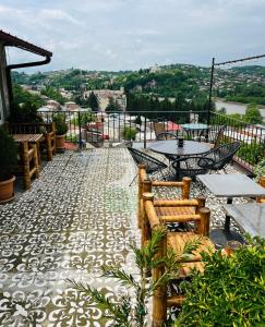 un patio con mesas y sillas en el balcón en Green Flower Hotel, en Kutaisi