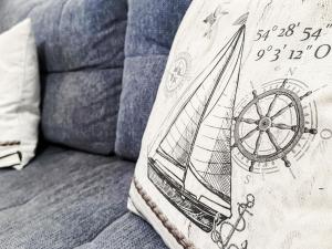 a pillow with a boat on it sitting on a couch at FeWo Meeresflimmern An der Aue 6b Whg11 in Dahme