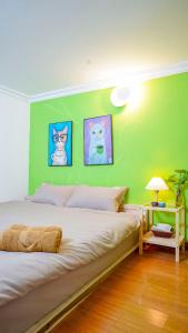 a bedroom with a green wall with a bed at Happy Home - Nhà phố cổ in Hanoi