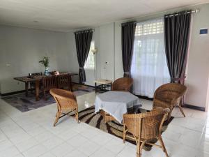sala de estar con mesa y sillas en Porlak Hebron Family Homestay en Siborongborong