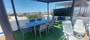 un patio con una mesa azul y sillas en la azotea en Casa totalmente nueva a 50 metros de la playa en El Palmar