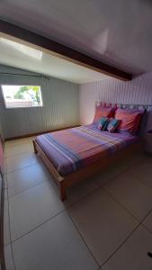 ein kleines Bett in einem Zimmer mit Fenster in der Unterkunft La case d'Isabelle in Saint-Denis