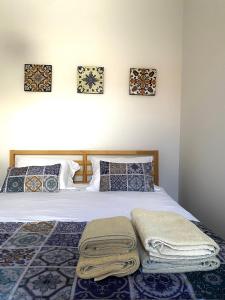 a bedroom with a bed with towels on it at Casa Devesas in Vila Nova de Gaia