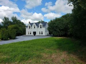 duży biały dom siedzący na podjeździe w obiekcie Home in Ennis w mieście Ennis