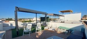 un patio con sillas y mesas en la azotea en Casa totalmente nueva a 50 metros de la playa en El Palmar