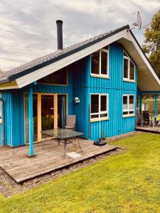 ein blaues Haus mit einem Picknicktisch auf einer Terrasse in der Unterkunft Komfort-Ferienhaus Wolke #56 in Extertal