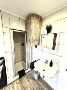 a white bathroom with a sink and a shower at Gemütliches Alpenblick BERG-Bungalow + großer GARTEN + NETFLIX! in Schöfweg +74 photos
