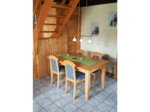 ein Esszimmer mit einem Holztisch und Stühlen in der Unterkunft Komfort-Ferienhaus Wolke #56 in Extertal