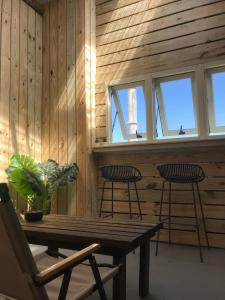 Habitación con pared de madera, mesa y sillas. en 海邊小屋 en Green Island