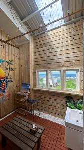 Habitación con paredes de madera, banco y ventanas. en 海邊小屋 en Green Island