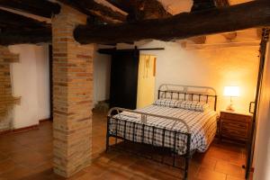 1 dormitorio con cama y pared de ladrillo en Masia en plena naturaleza y tranquilidad, en Sant Quintí de Mediona
