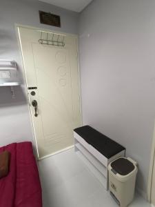 Habitación pequeña con puerta y cubo de basura en ROOMSTAY NIMAZA Bilik 2, en Marang