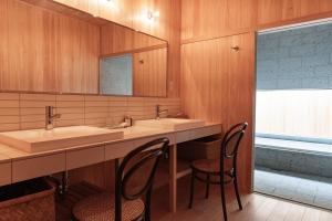 un bagno con due lavandini e due sedie di Yasoichi a Tamba-sasayama