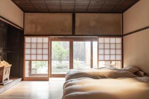 una camera da letto con due letti e una grande finestra di Yasoichi a Tamba-sasayama