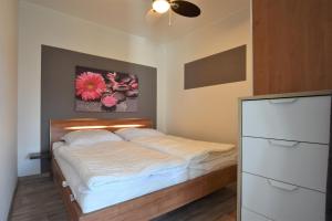a bedroom with a bed and a painting on the wall at FeWo Sunshine-Dahme in Dahme