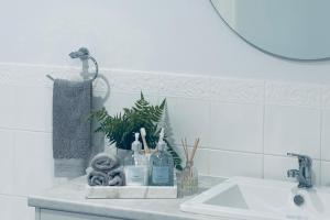 eine Badezimmertheke mit einem Waschbecken und einem Spiegel in der Unterkunft U2 at Moana Beach Esplanade - Exclusive 2 Bdrm Apt - WiFi - Spa - Pet Friendly in Moana