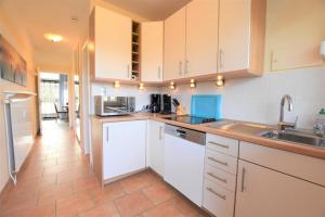 a kitchen with white cabinets and a sink at FeWo Sunshine-Dahme in Dahme