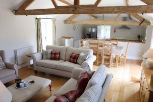 a living room with two couches and a dining room at Clayhanger Lodge in Abbotsbury
