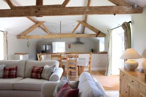 a living room with a couch and a dining room at Clayhanger Lodge in Abbotsbury