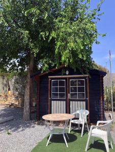 a picnic table and two chairs in front of a shed at Camping Santa Clara in Altea