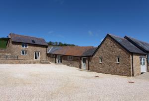 a group of three brick buildings with a driveway at Clayhanger Lodge in Abbotsbury