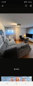 NJoy Apartments في نورنبرغ: غرفة معيشة مع سرير كبير وتلفزيون بشاشة مسطحة