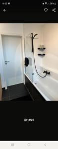 a bathroom with a shower with a hose at NJoy Apartments in Nürnberg