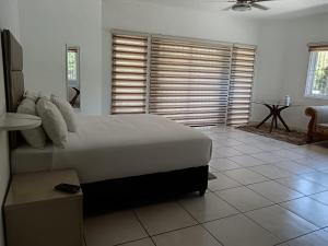 um quarto com uma grande cama branca e uma mesa em The Rose on Fairway em Durban