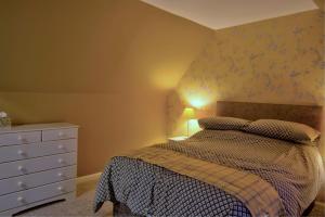 Un pat sau paturi într-o cameră la Otago Cottage, Brora