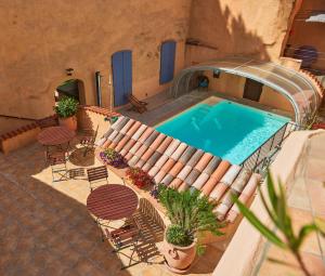 an overhead view of a swimming pool with chairs and a patio at Les Arcades Le Lion D'or in Buis-les-Baronnies