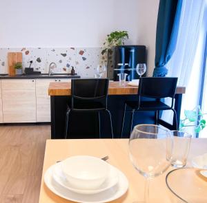 a table with a plate and two glasses on it at Aumetz square apartment in Idrija