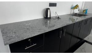 a granite counter top in a kitchen with black cabinets at Shakin Shasha Beach House/neithalbeachcity in Jaffna
