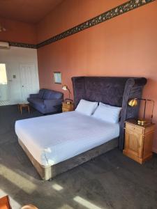 Un dormitorio con una cama grande y un sofá. en The Macquarie Hobart, en Hobart