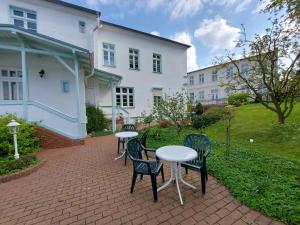 a patio with two tables and chairs and a building at Haus Lucie 50m bis zum Ostseestrand in Heringsdorf
