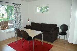 a living room with a couch and a table and chairs at Björketorps Stugby in Vissefjärda