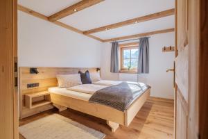 ein Schlafzimmer mit einem Holzbett und einem Fenster in der Unterkunft Ferienwohnung Kirchern in Aurach bei Kitzbuhel