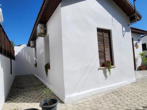 a white house with a window and potted plants at Mystic Guest House Famagusta in Famagusta