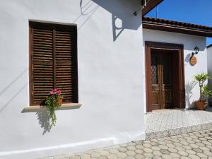 Mystic Guest House Famagusta في فاماغوستا: مبنى أبيض مع نافذة ونبات الفخار